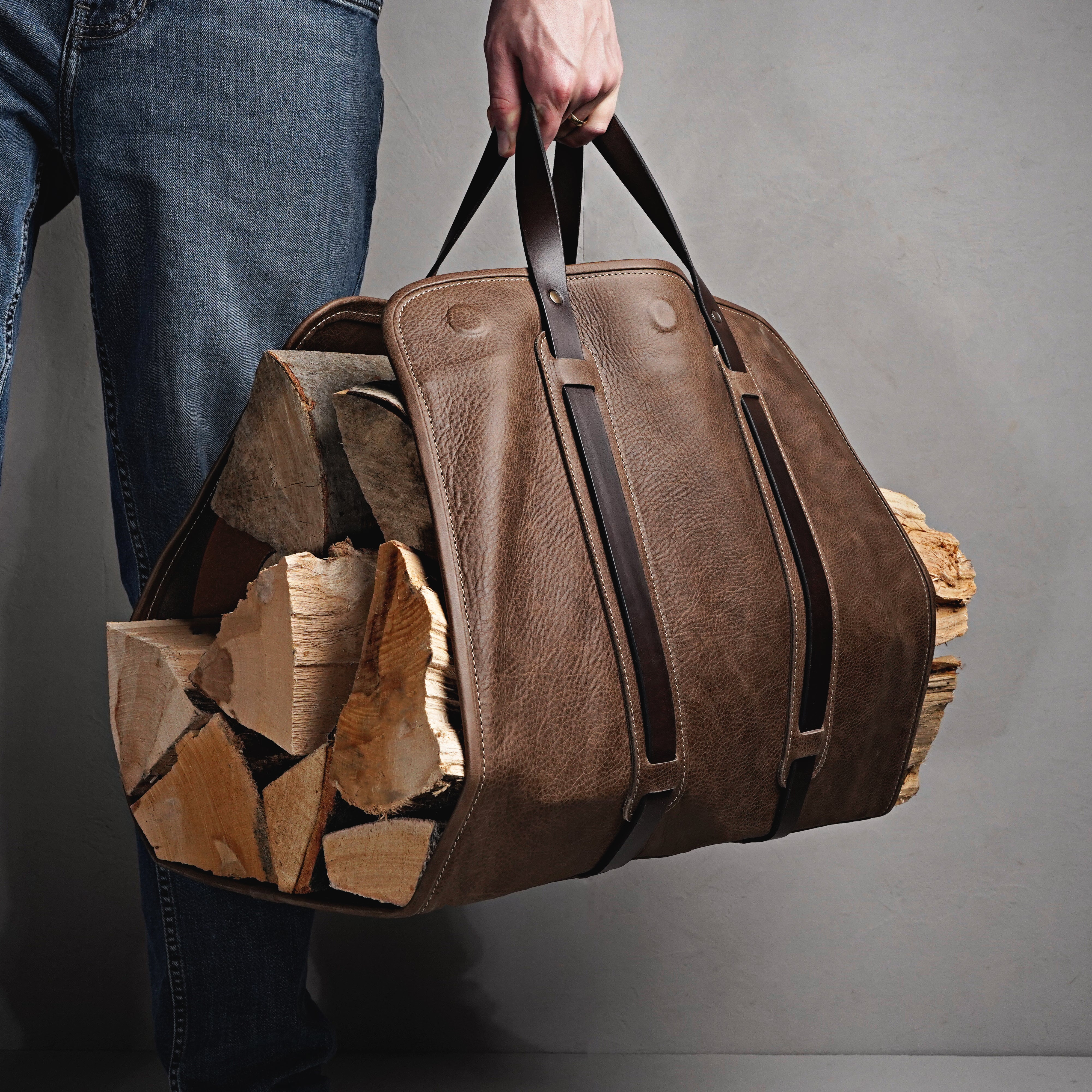 Leder Kaminholztasche mit Holzscheiten getragen